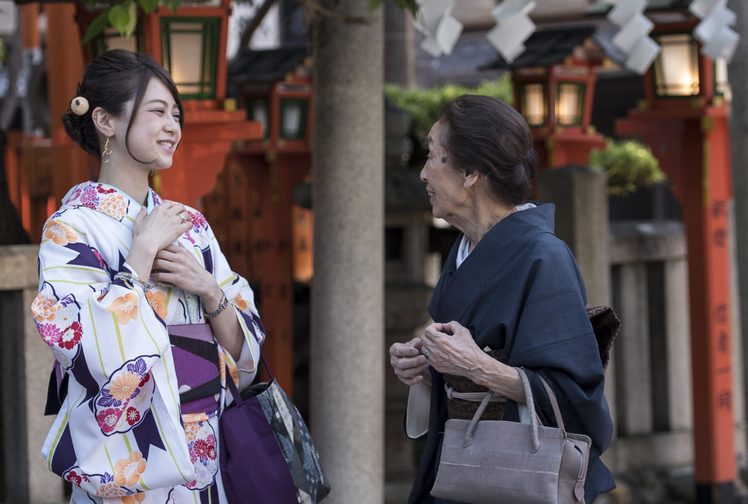 Begegnung in Japan: Zwei in traditionelle Kimonos gekleidete Frauen unterhalten sich bei der Gion Tatsumi Brücke.